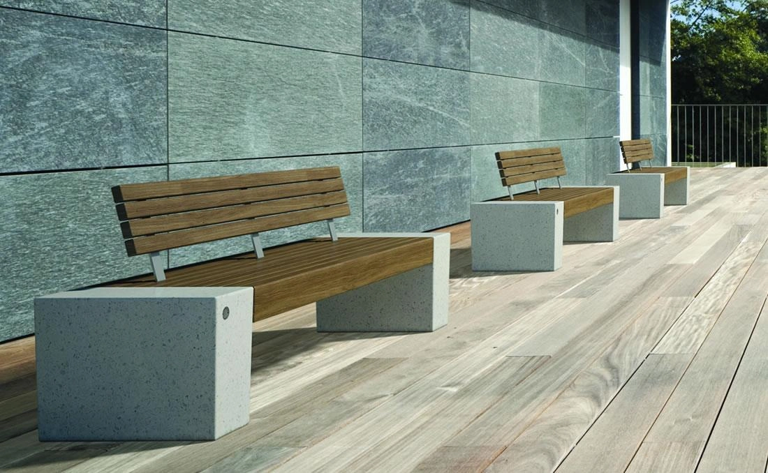 Bancos urbanos Eraclea con respaldo de madera y base de hormigón.